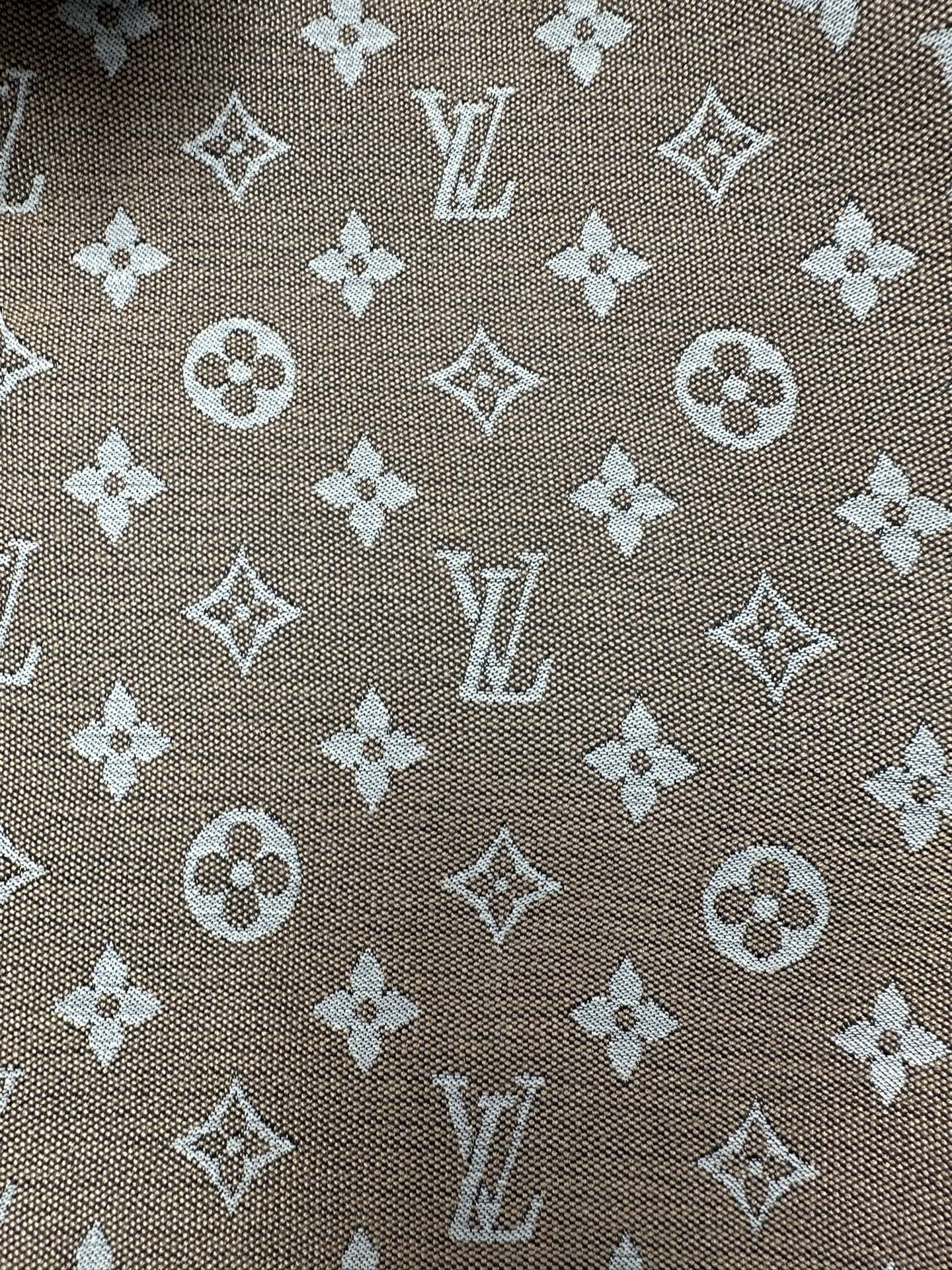 Monogram pattern fabric close-up in brown with light-beige motifs