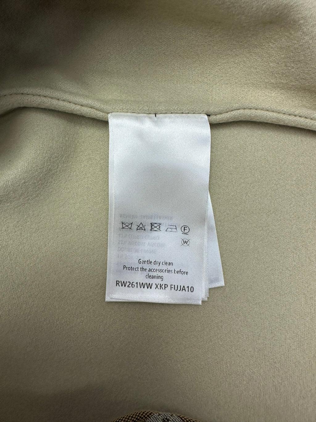 Jacket care label tag inside, white paper label on light-beige lining
