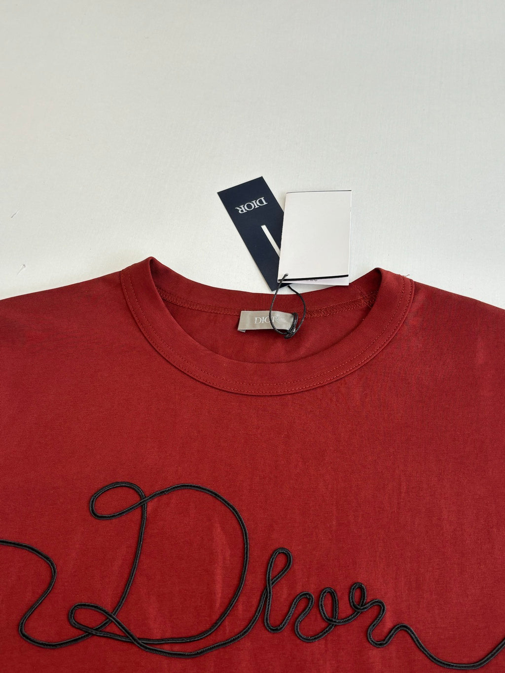 Dior red T-shirt neckline and black cursive logo detail