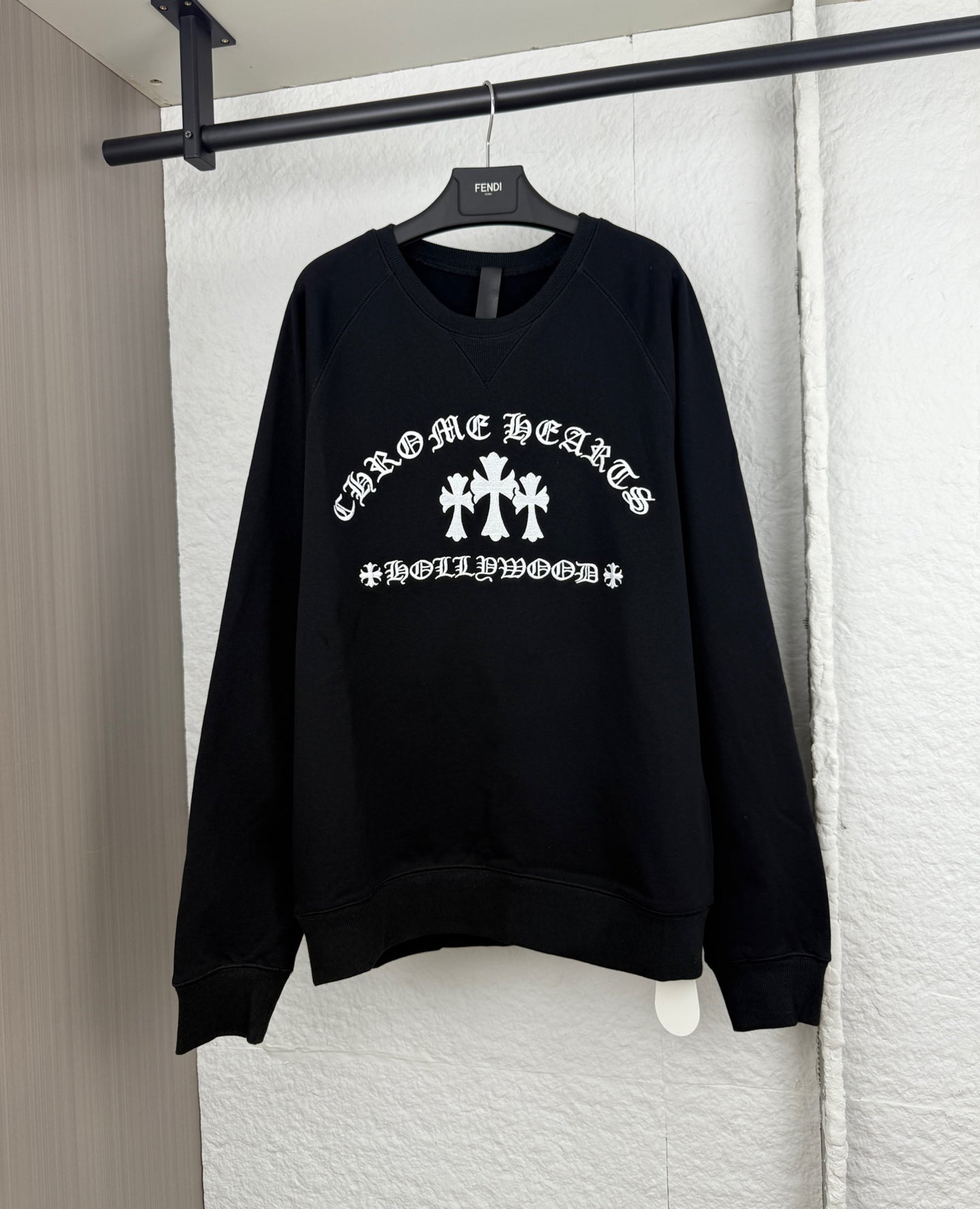 Black long-sleeve sweatshirt with white graphic logo across the chest