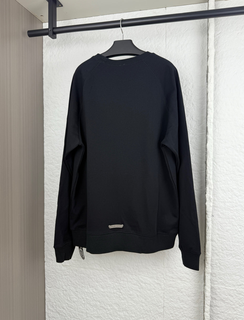 Black long-sleeve sweatshirt, back view with relaxed crewneck and cuffs