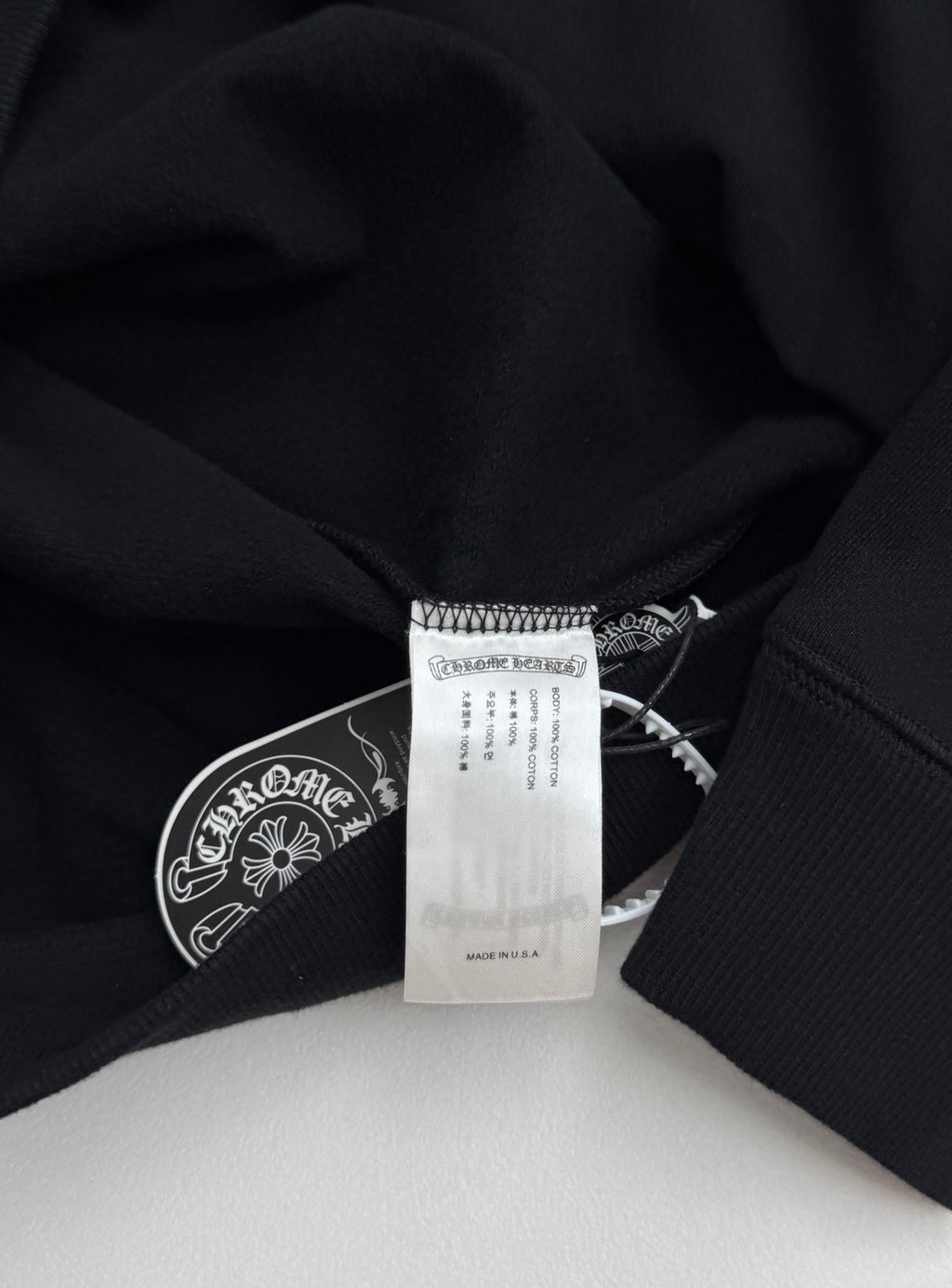 Black sweatshirt neckline with sewn label and inner care tag