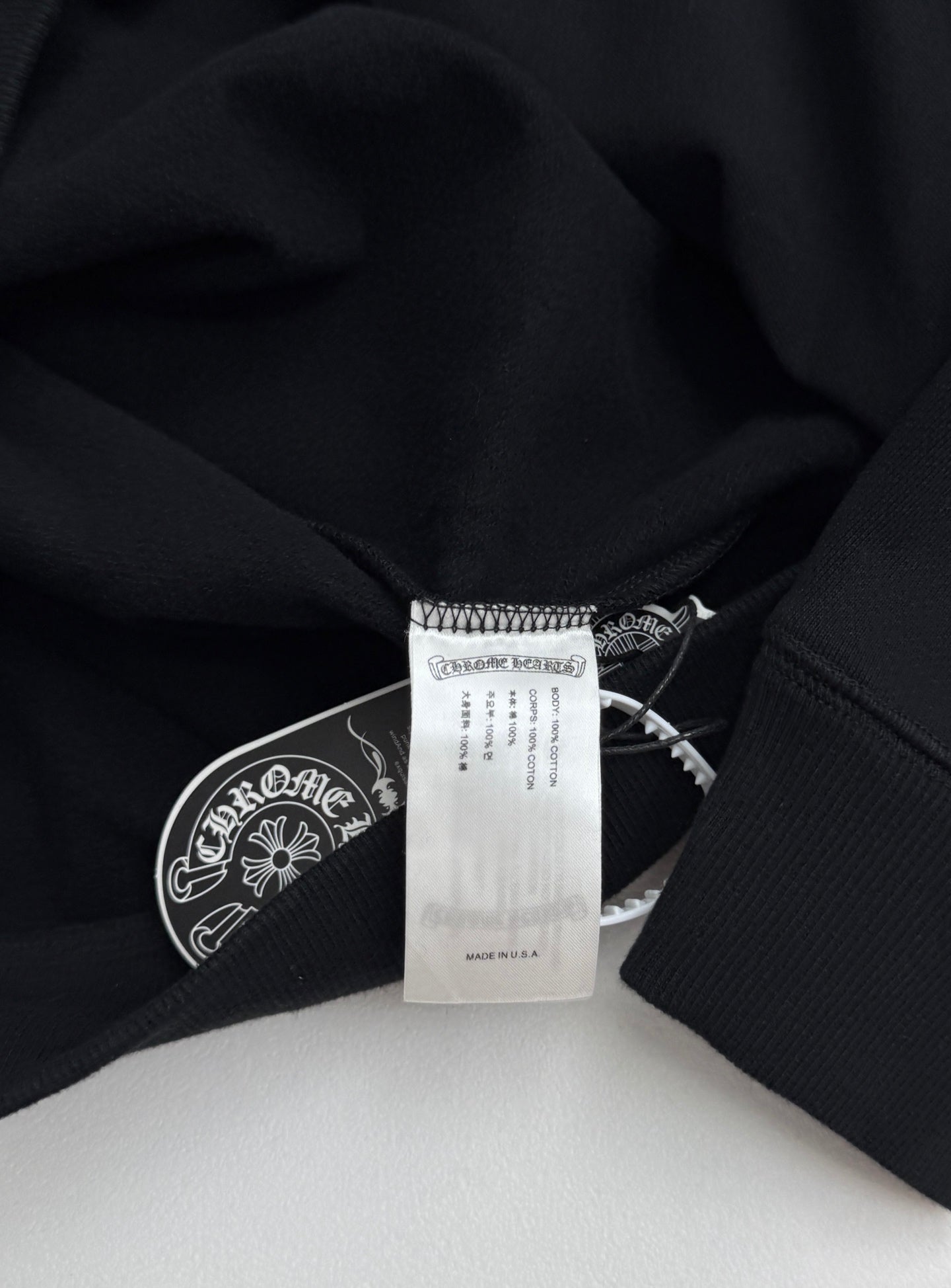 Black sweatshirt neckline with sewn label and inner care tag