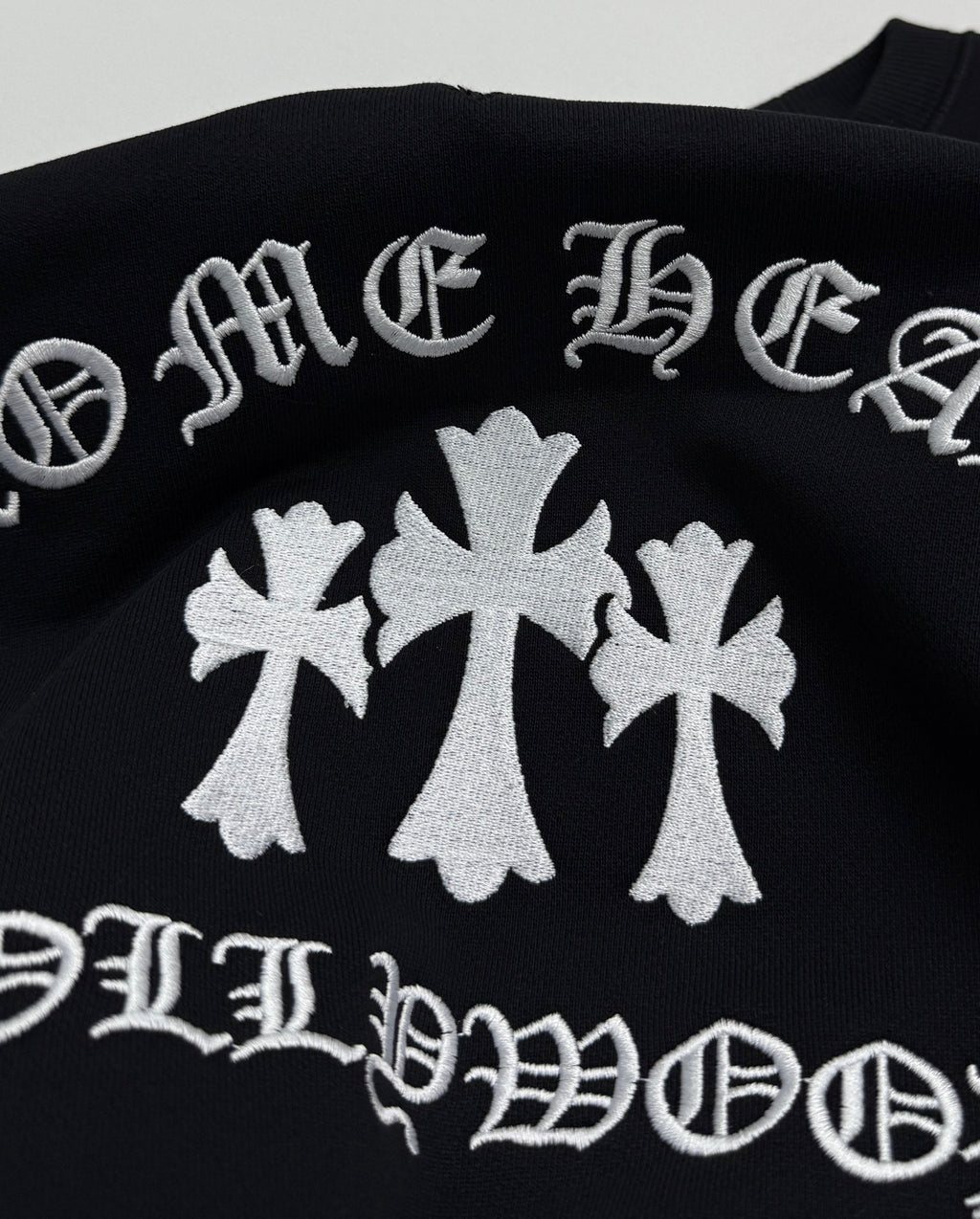 Black sweatshirt with large white flower graphic and curved text print