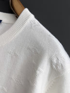 White ribbed knit crewneck and shoulder area of Louis Vuitton sweatshirt, close-up