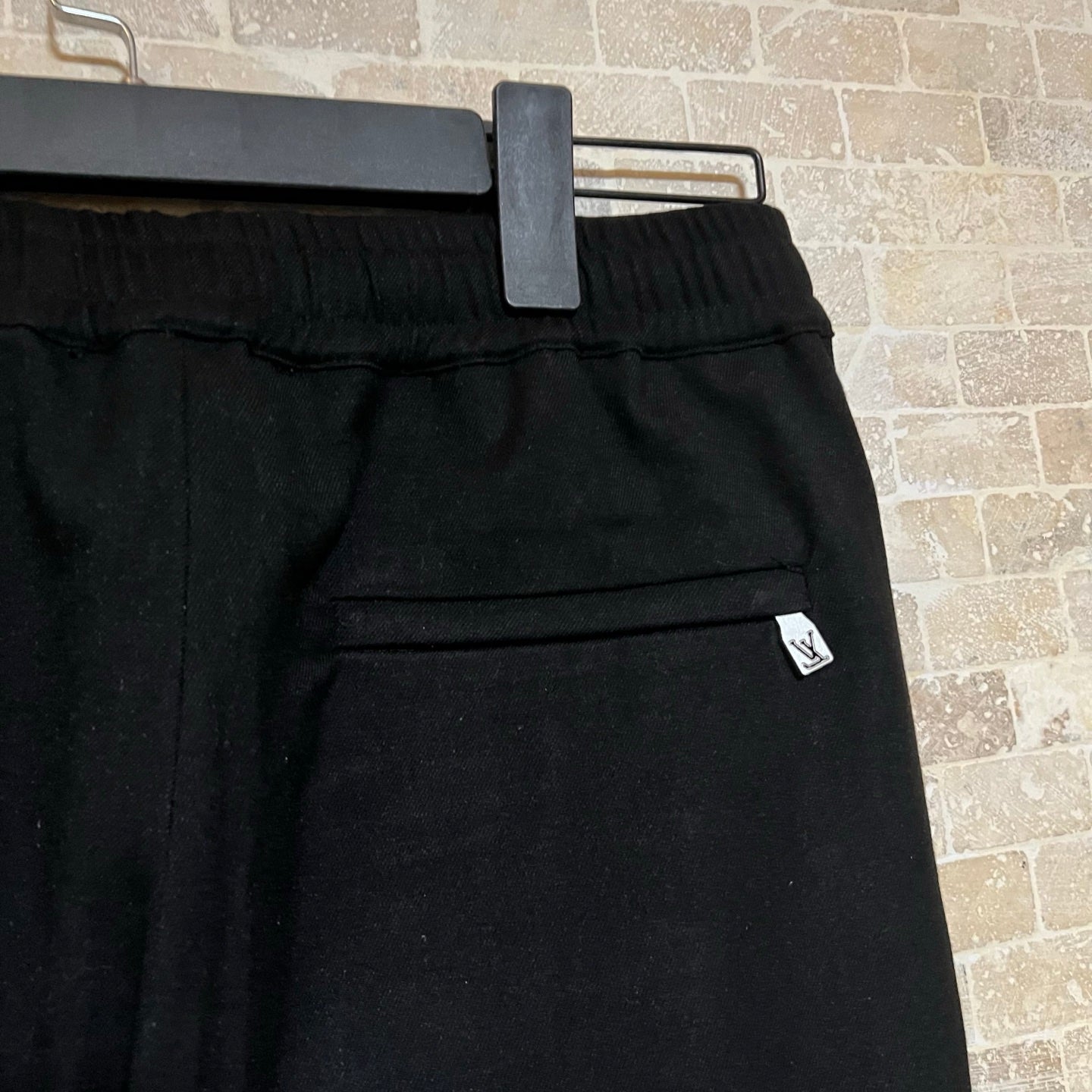 Black pants waist band with belt loops and small LV logo patch