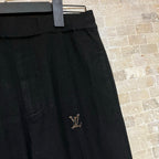 Black pants close-up of thigh LV emblem and stitched side seam