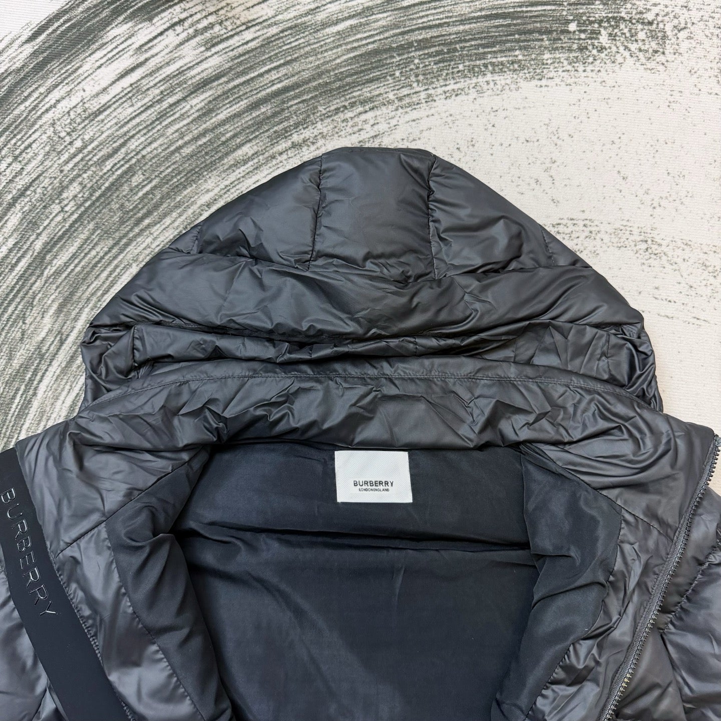 Dark puffer jacket interior view with Burberry logo label
