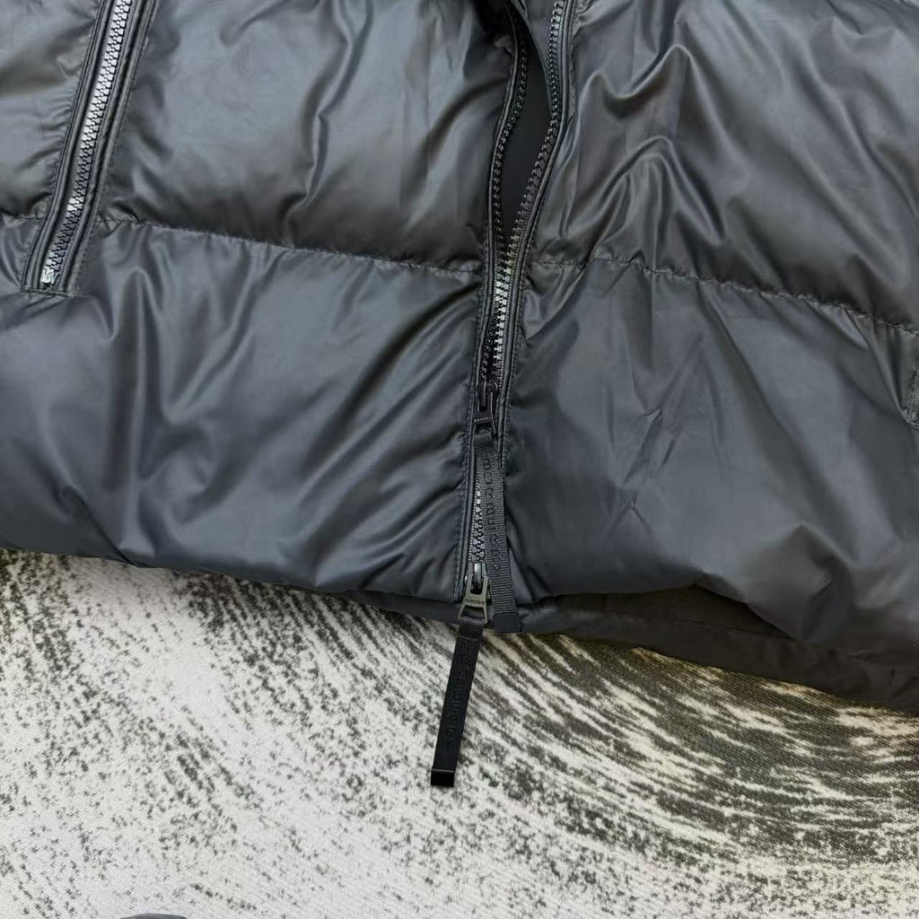 Dark puffer jacket front close-up with zipper and quilted panels