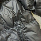 Dark puffer jacket sleeve and front zip pocket seam detail