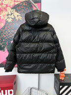 Black hooded puffer jacket with quilted panels and front zipper