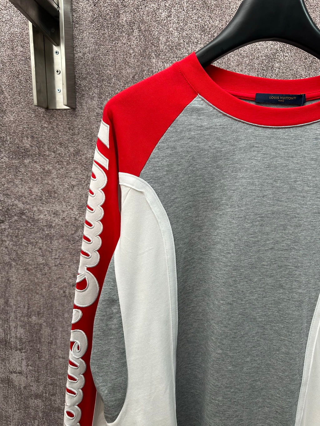 Raglan long-sleeve shirt with red sleeves, gray front, and white pocket-like panel