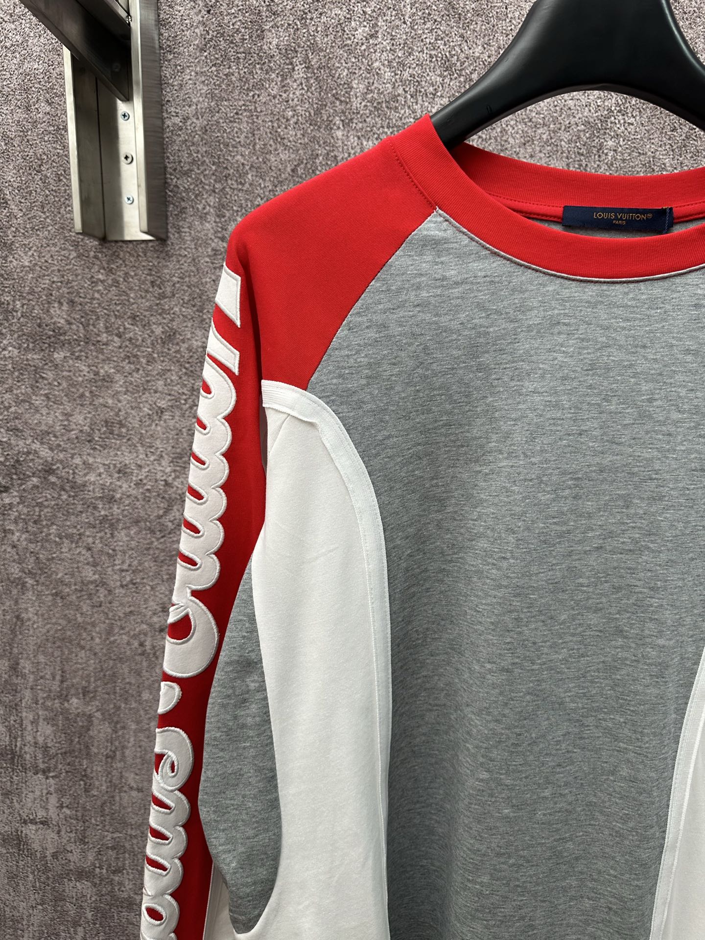 Raglan long-sleeve shirt with red sleeves, gray front, and white pocket-like panel