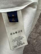 Clothing care label tag inside long-sleeve shirt, size M, fabric and washing icons