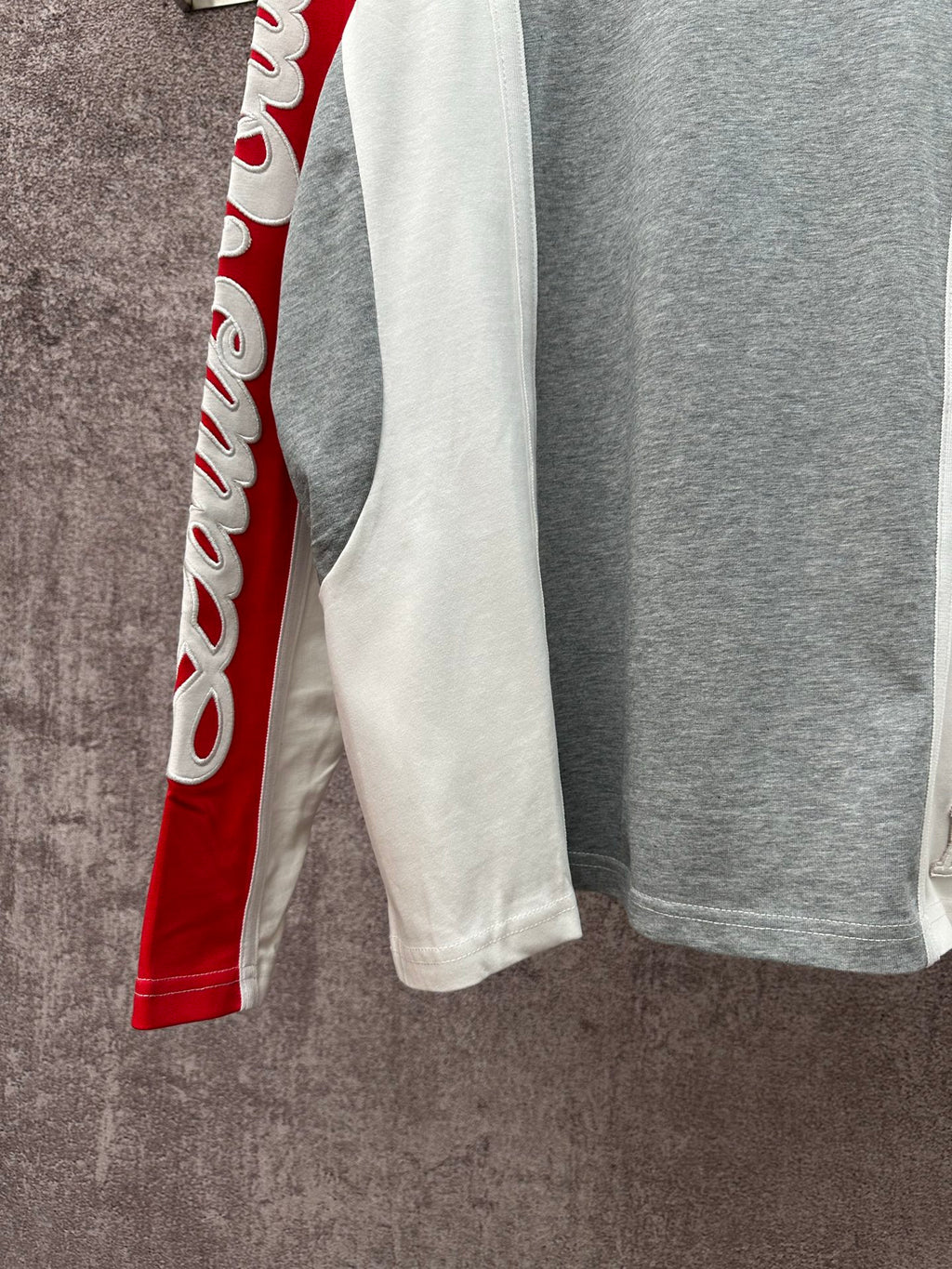 Long-sleeve raglan shirt with white side panel and red sleeve; gray main body