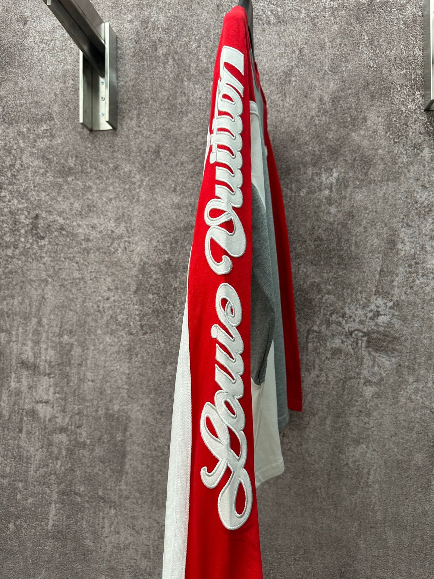 Long-sleeve raglan shirt viewed from side, with large red panel and white logo print