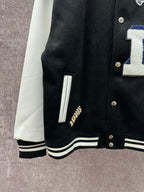 Black varsity jacket sleeve and hem with white stripe ribbing and gold-button placket