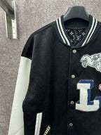 Black varsity jacket with white sleeves, button placket and crest graphic detail