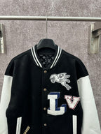 Black long varsity jacket with white sleeves, crest logo and LV letter patches on front