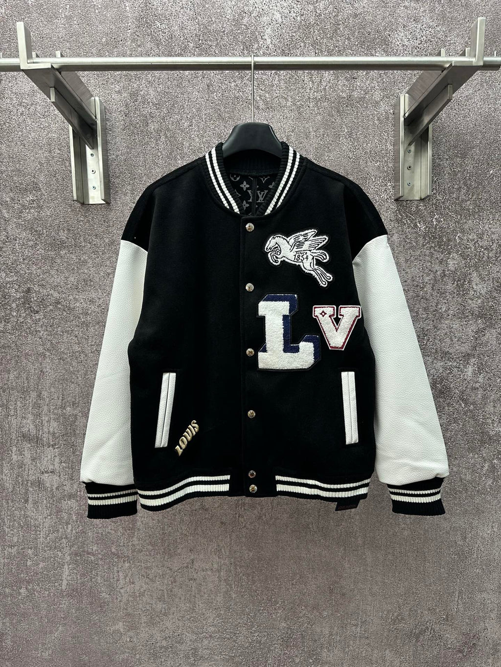 Black long varsity jacket with white sleeves, ribbed collar and button front