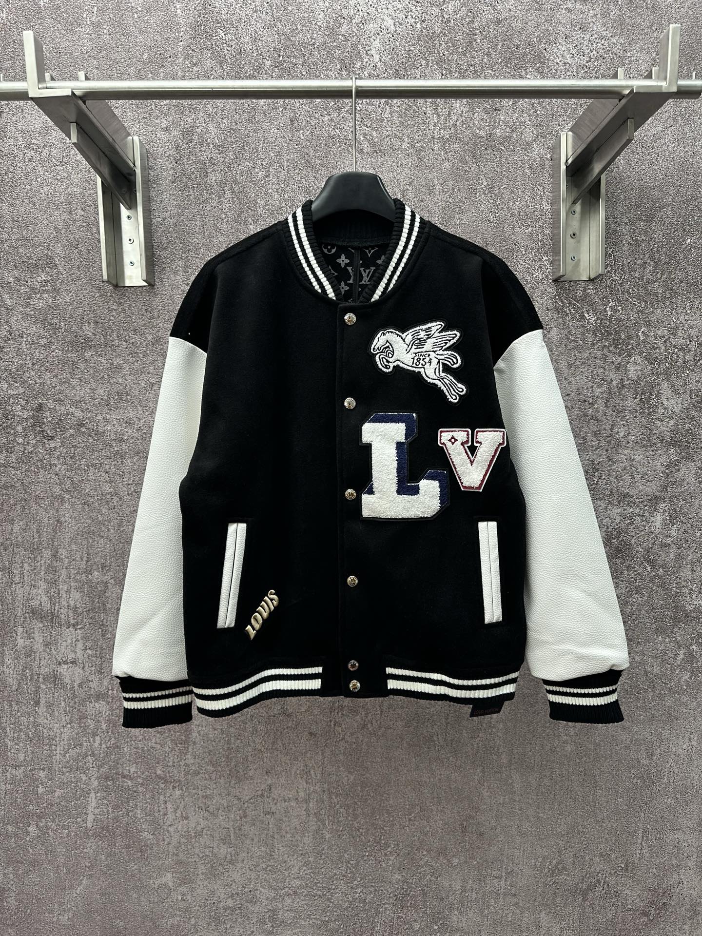 Black long varsity jacket with white sleeves, ribbed collar and button front