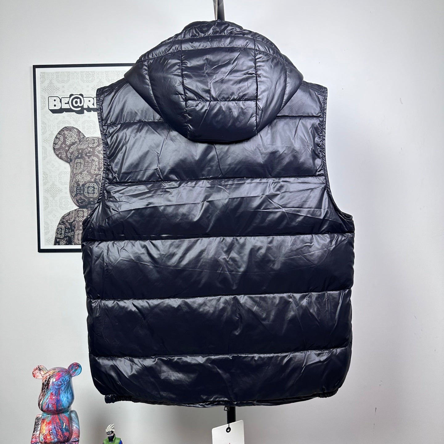 Moncler dark puffer vest back view with hood and horizontal quilted stripes