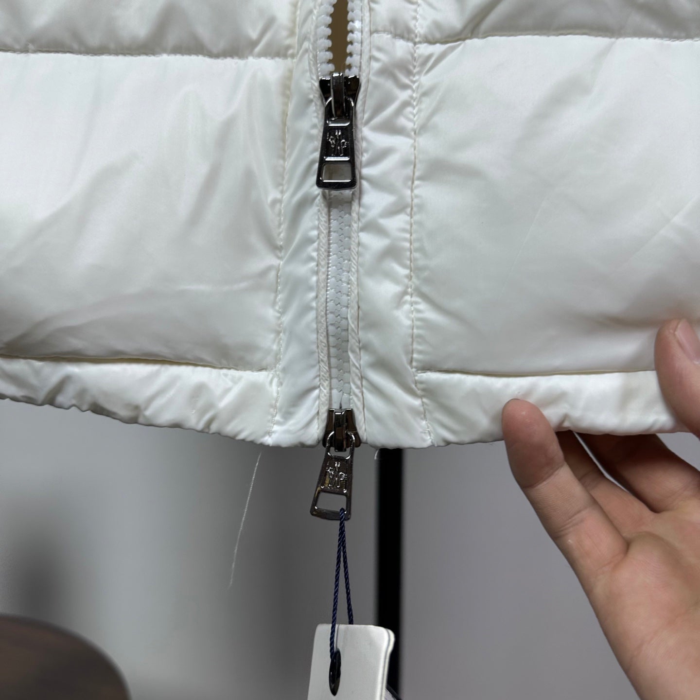 Moncler puffer vest, white, close-up of zipper pull and inner strap