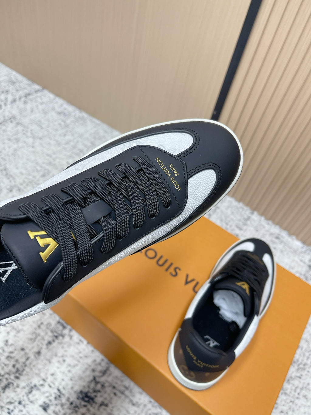 Louis Vuitton sneakers with textured outsole and black leather upper, gold LV accents