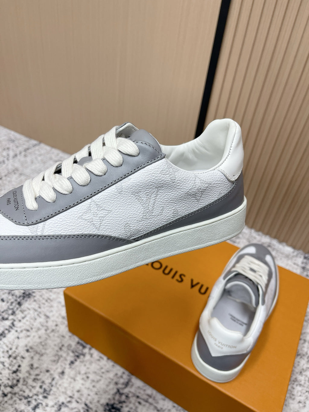 Low-top leather sneakers with white uppers and gray stripe, white laces, side logo