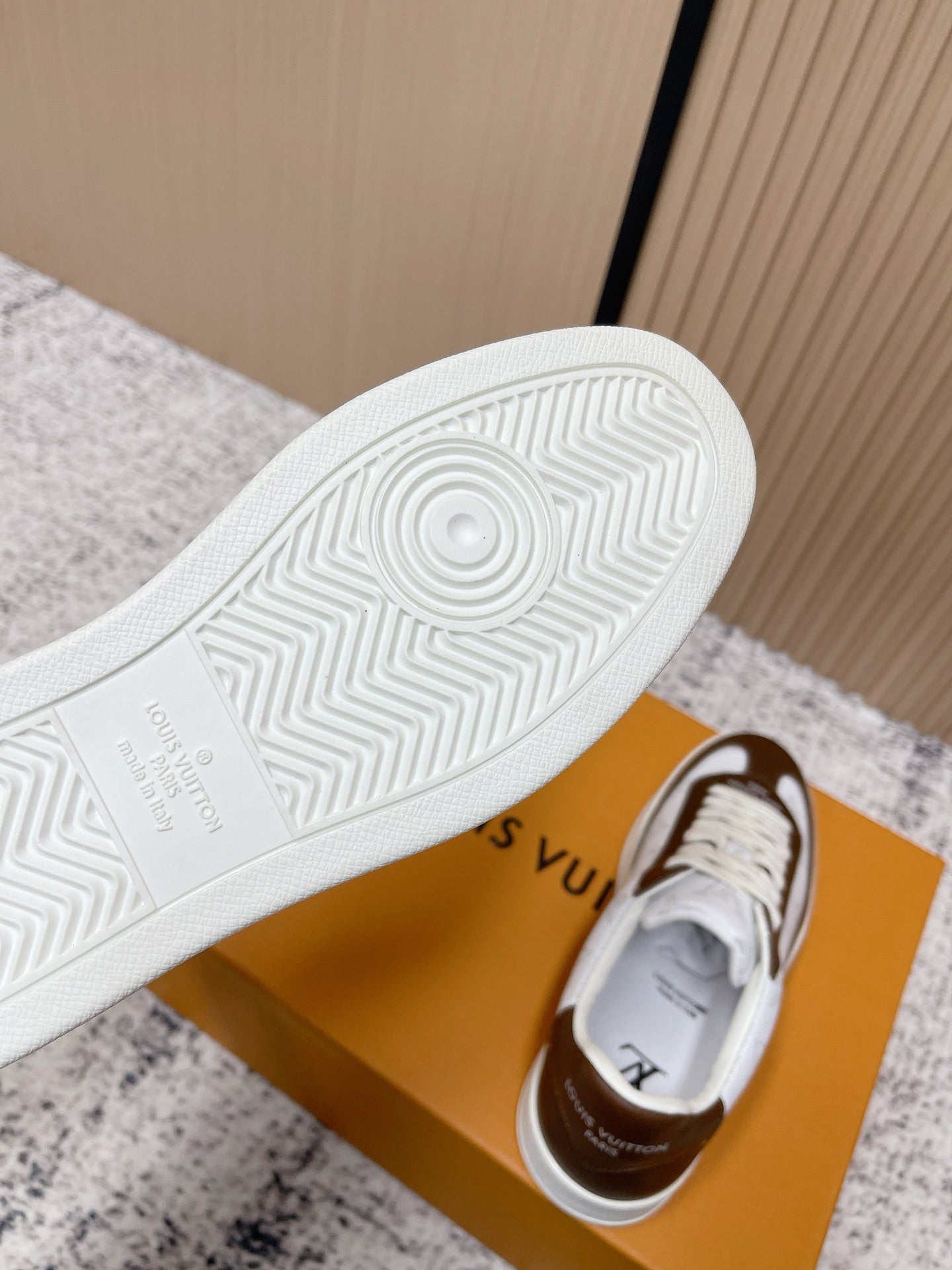 Brown-and-white sneaker outsole with textured tread and circular traction pattern