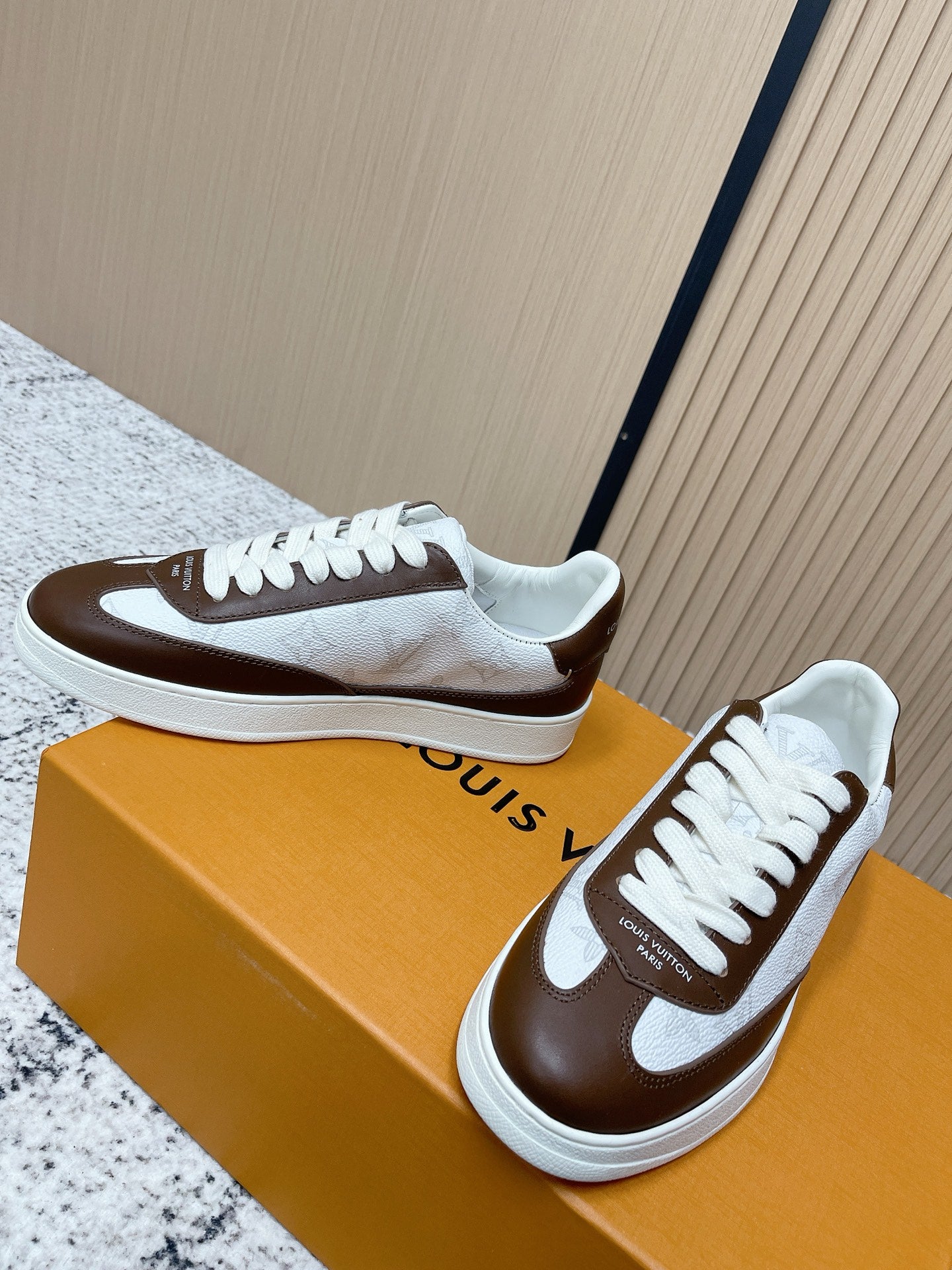 Brown-and-white low-top sneakers, side view with white laces and logo trim