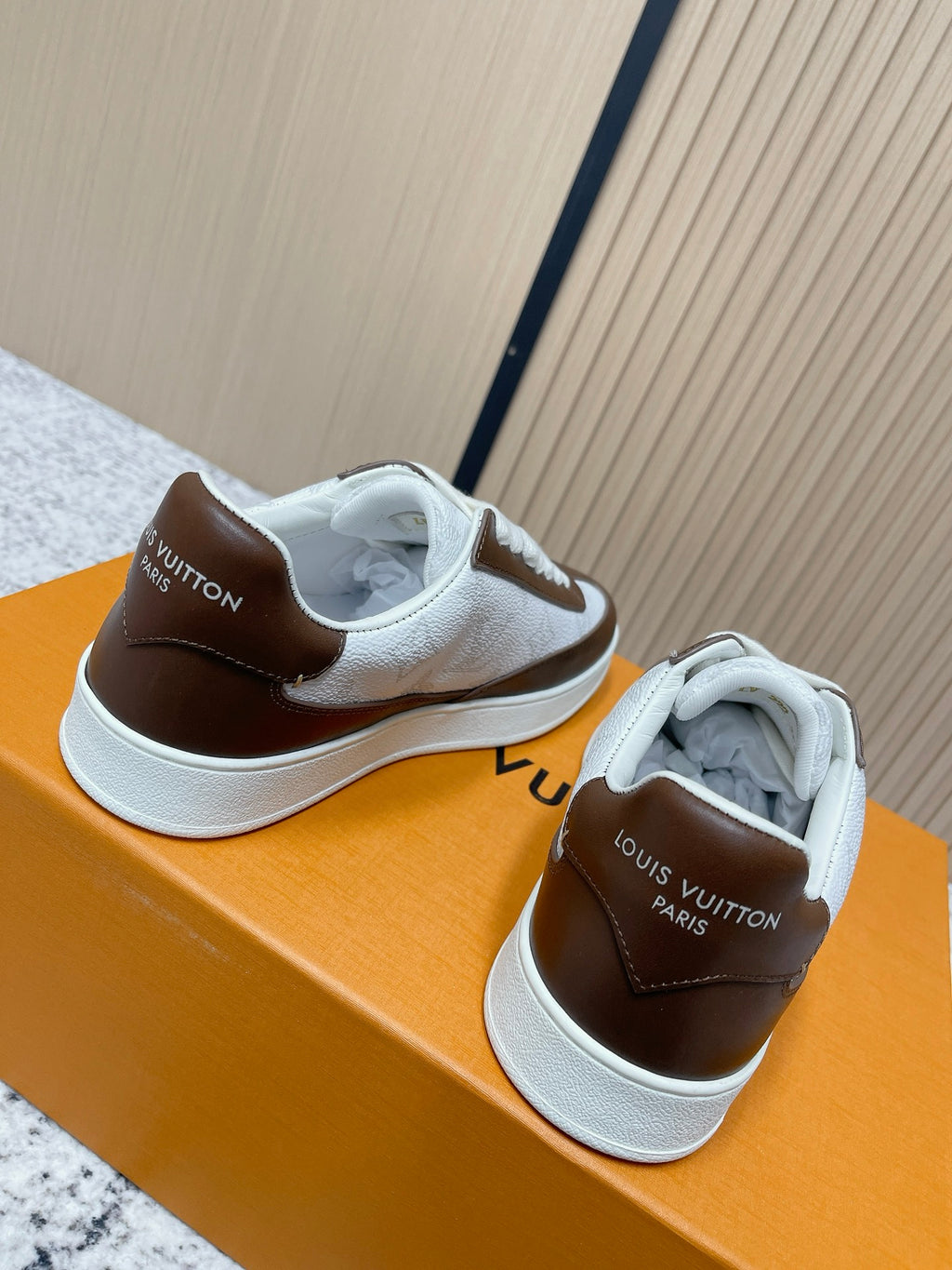 Brown-and-white low-top sneakers with embossed logos and white rubber sole