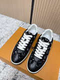 Black low-top sneakers with white laces and patterned sides, shown pair-on shoe box.