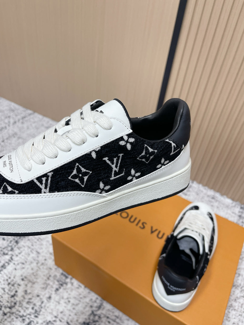 Louis Vuitton unisex sneakers, angled profile with black monogram upper and white toe cap