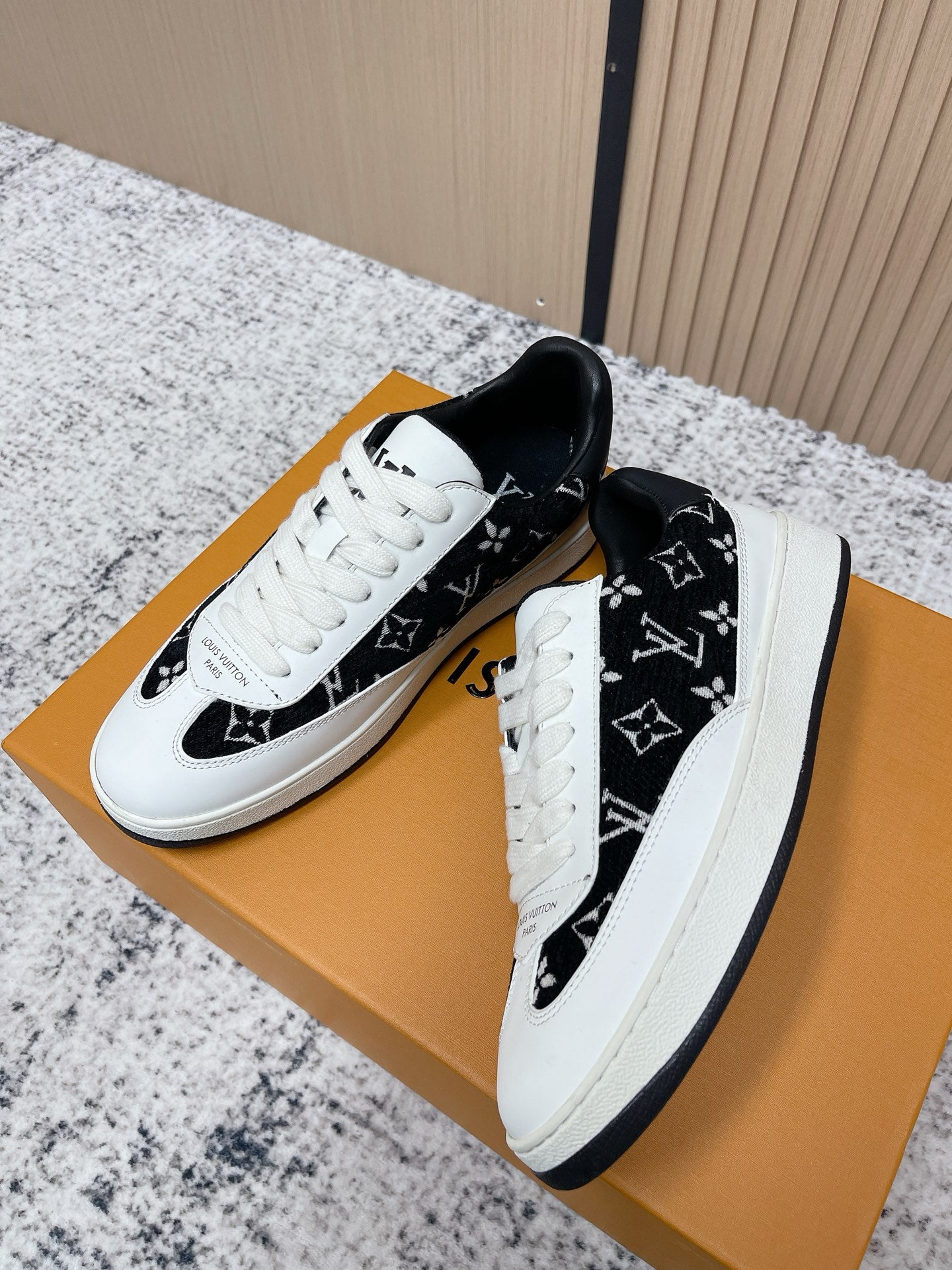 Louis Vuitton unisex sneakers, side view with black monogram upper and white laces
