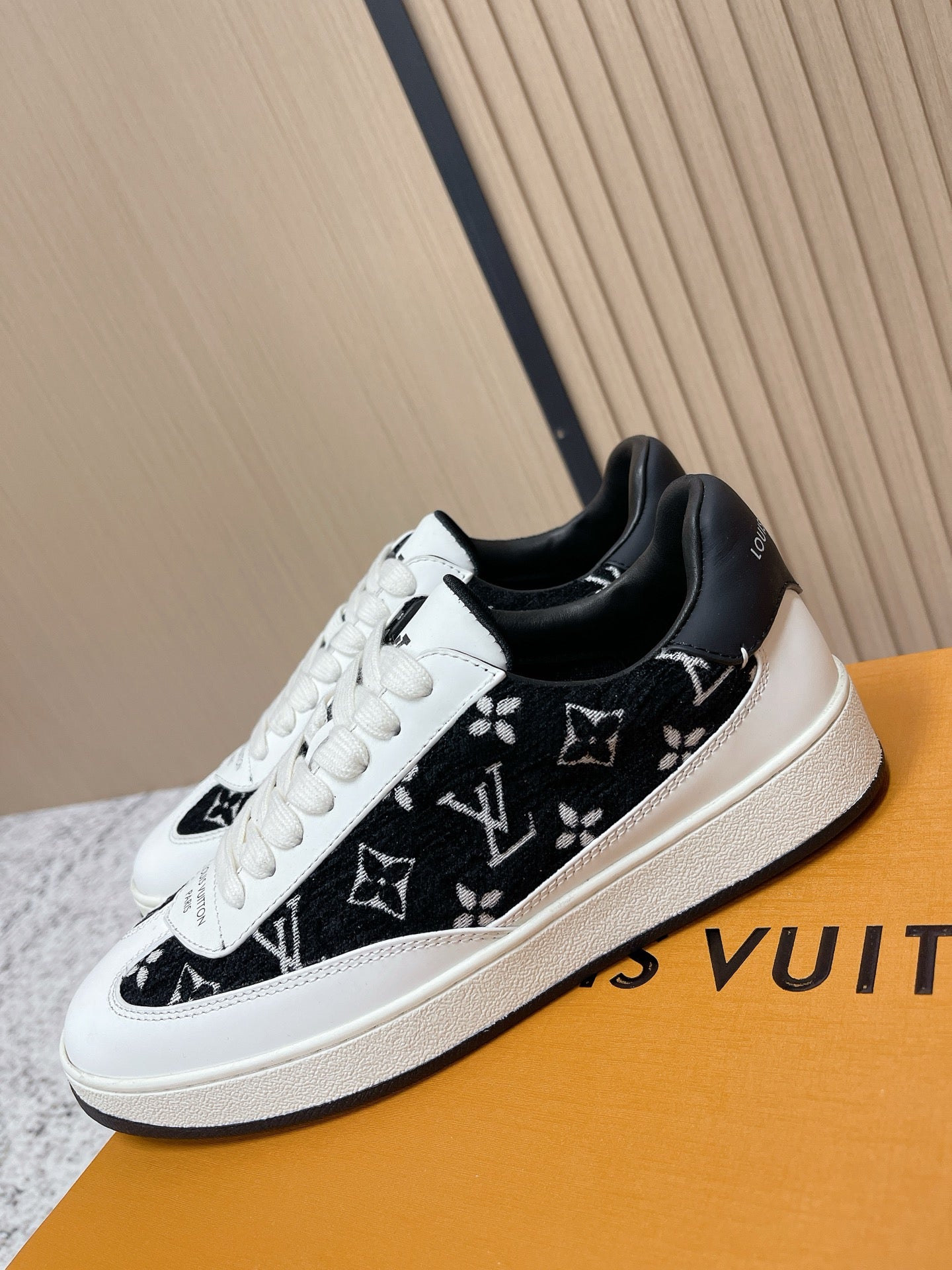 Louis Vuitton unisex sneakers, close side view with black monogram print and white laces