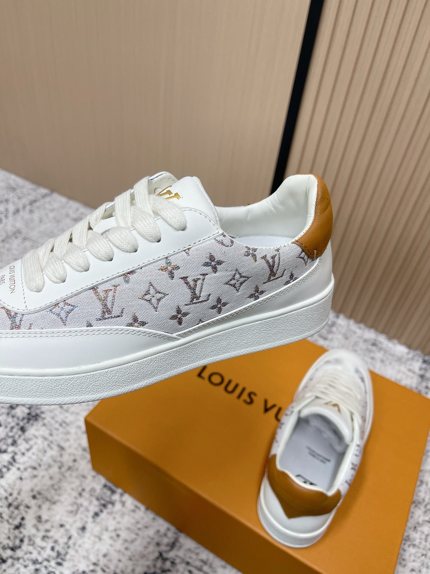 Louis Vuitton unisex sneakers, side view in white with monogram stripe and gold heel lining