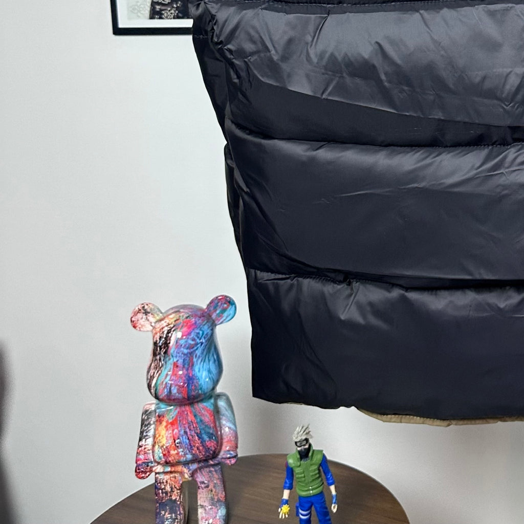 Long Moncler puffer jacket front view with dark navy hood and quilted torso