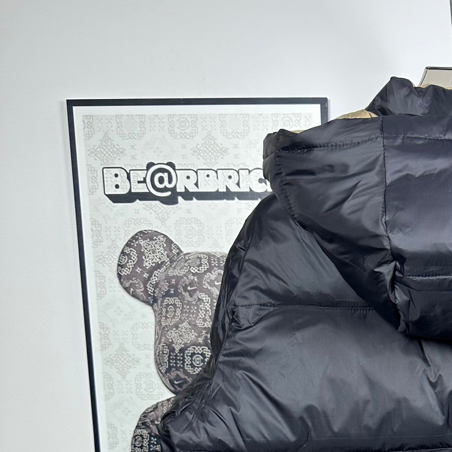 Long Moncler puffer jacket back view with dark navy hood and quilted stripes