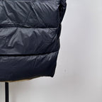 Long Moncler puffer jacket with dark navy quilted panels and curved hem
