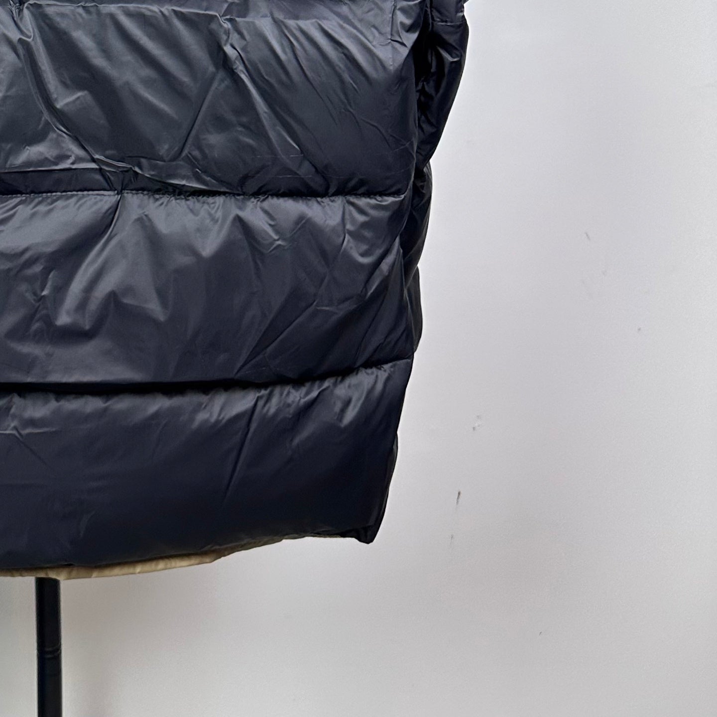 Long Moncler puffer jacket with dark navy quilted panels and curved hem