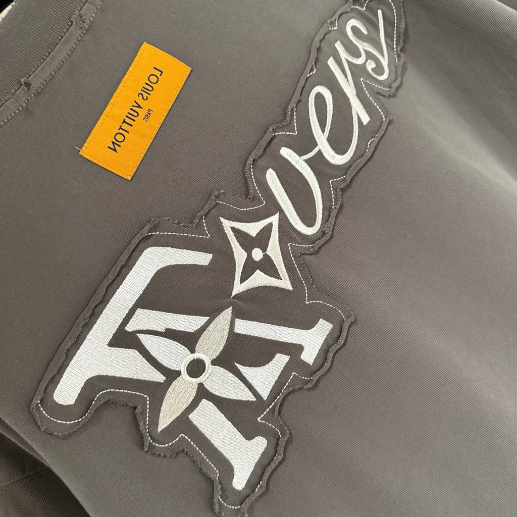 Louis Vuitton T-shirt front graphic with LV-style emblem, yellow care label
