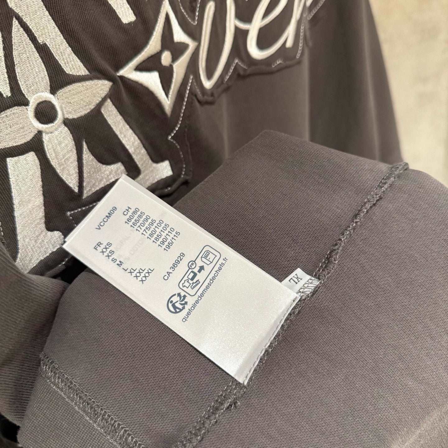 Louis Vuitton T-shirt inner care label on dark gray fabric near neckline