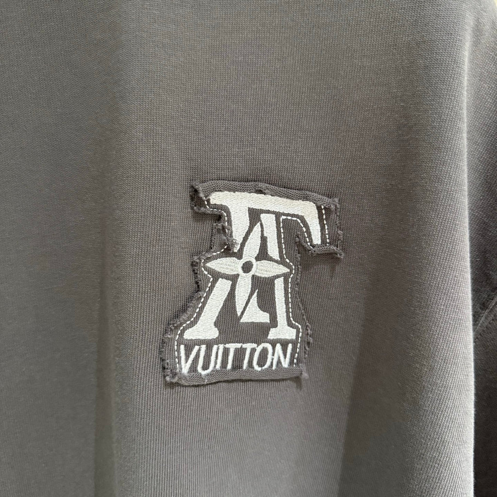 Louis Vuitton logo patch on dark gray T-shirt, embroidered emblem at chest