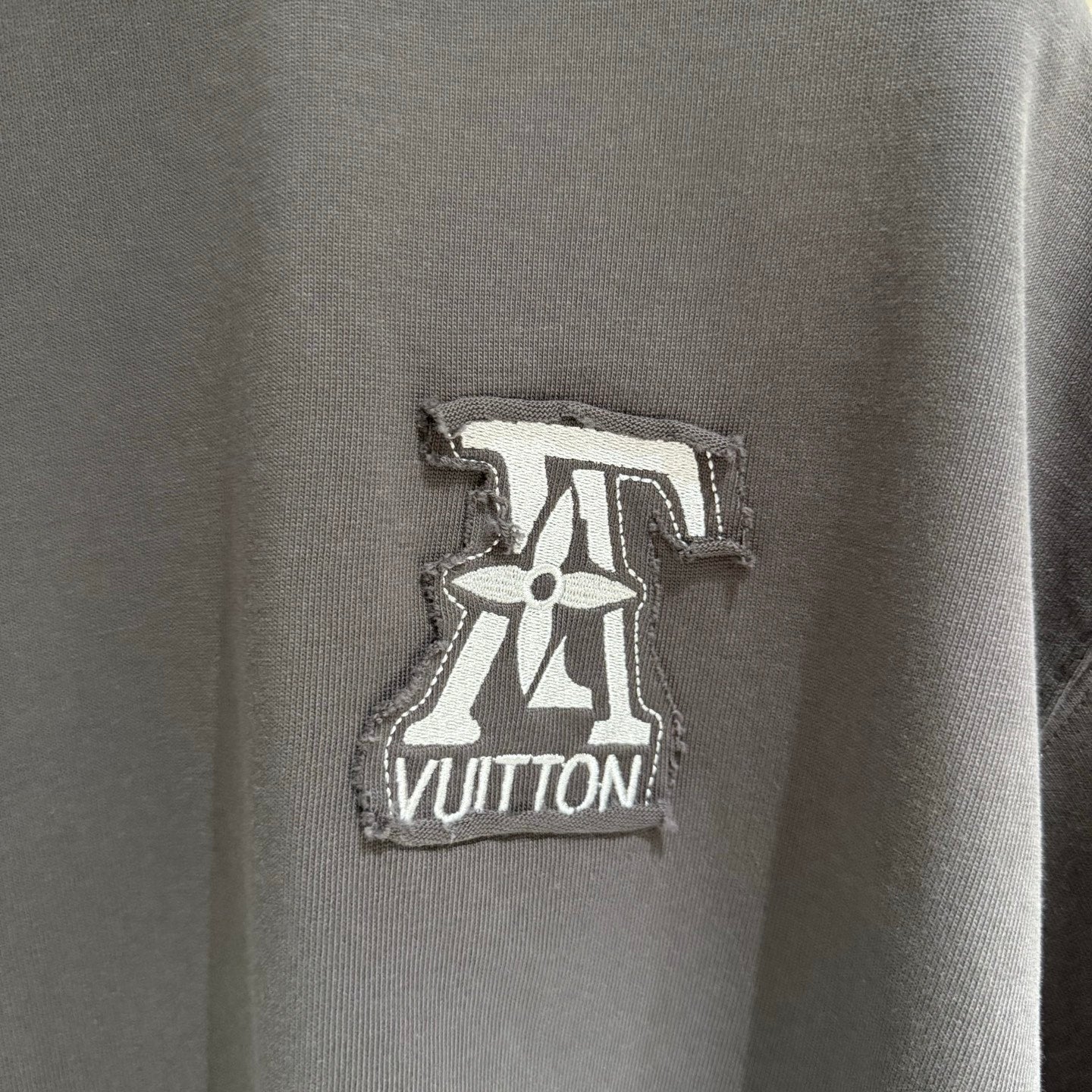Louis Vuitton logo patch on dark gray T-shirt, embroidered emblem at chest