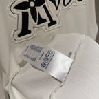 White T-shirt with large embroidered 'Tovers' graphic and fabric care label