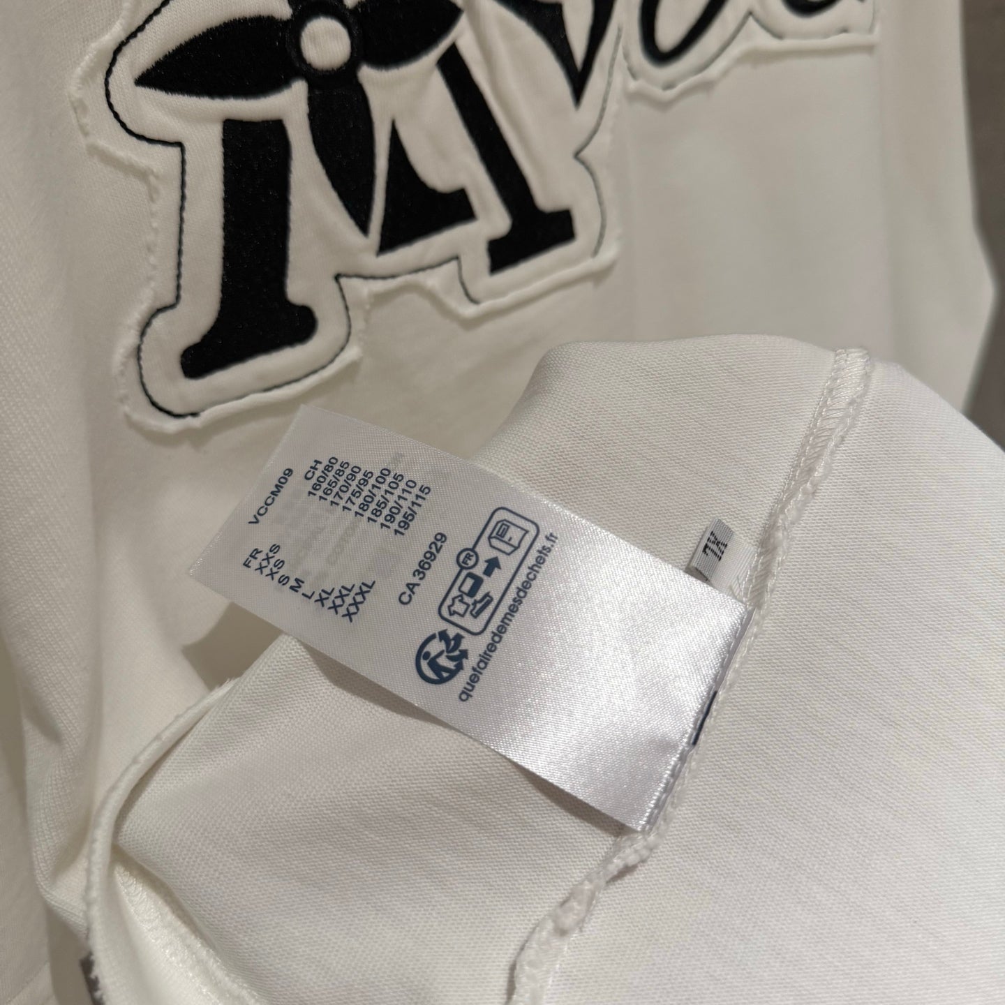 White T-shirt with large embroidered 'Tovers' graphic and fabric care label