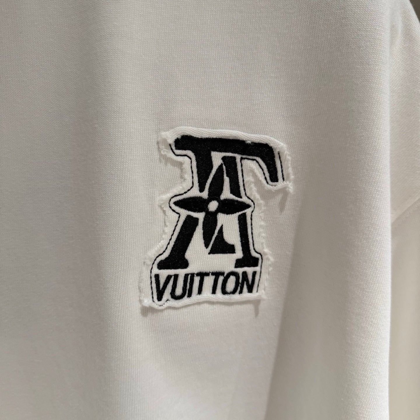 White T-shirt with embroidered black Louis Vuitton logo patch on chest