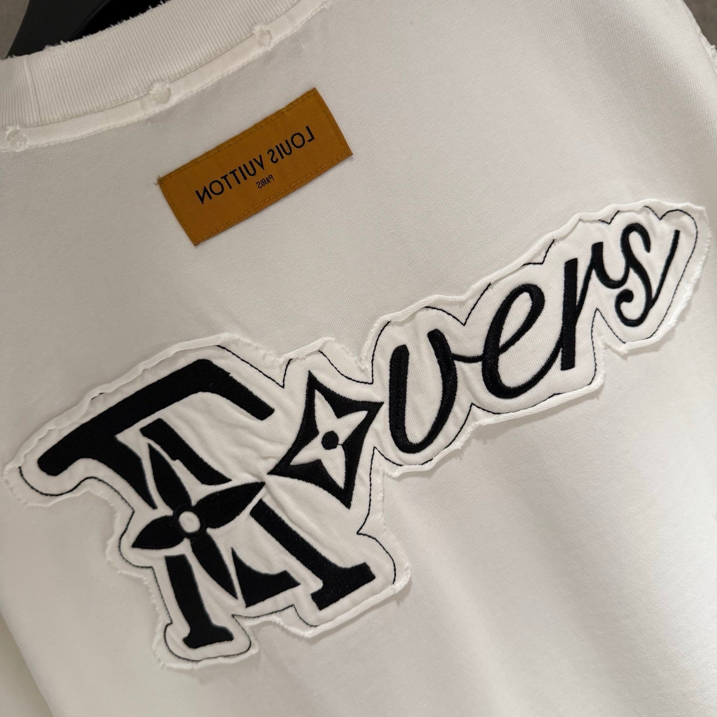 White T-shirt with large embroidered 'Tovers' graphic and brown neck tag