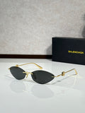 Balenciaga sunglasses with dark tinted lenses and gold-tone metal frame.